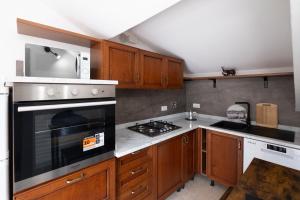 Una cocina con gabinetes de madera y un horno de estufa. en Il Nido dei Sogni, en Imperia