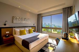a bedroom with a bed and a desk and a window at The Ray Hotel and Studios in Beirut