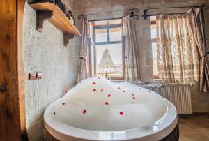 a bath tub in a room with a window at Chelebi Cave House in Göreme +33 photos