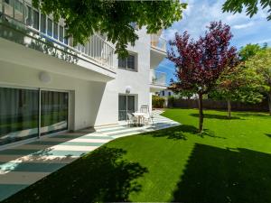a courtyard of a building with a table and a tree at Apartamentos Sunway Atlanta in Sitges