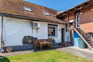 a house with a patio with a wooden table at Kleines Glück in Seedorf