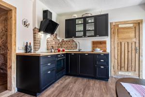 a kitchen with black cabinets and a wooden floor at Kleines Glück in Seedorf