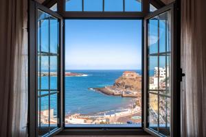 een open raam met uitzicht op de oceaan bij Bahía Apartments in Icod de los Vinos