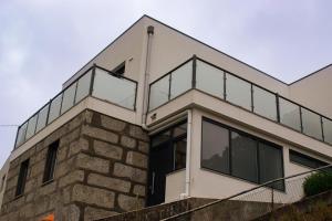a house with glass railings on top of a brick building at Casa do Barreiro in Baião
