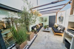 a living room with a couch and some plants at Elements Milfontes - Japandi Designed House - City Center in Vila Nova de Milfontes