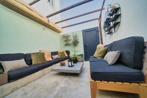 a living room with a blue couch and a table at Elements Milfontes - Japandi Designed House - City Center in Vila Nova de Milfontes
