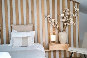 a bedroom with a bed and a vase with flowers at Elements Milfontes - Japandi Designed House - City Center in Vila Nova de Milfontes +38 photos