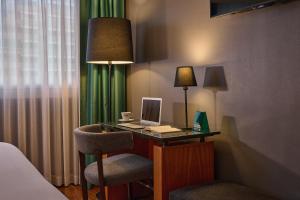 a desk with a laptop and a chair in a hotel room at Hotel Malcom and Barret in Valencia