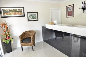 a dining room with a white counter and chairs at Pioneer Motel Goondiwindi in Goondiwindi