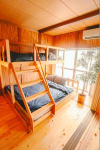 a bedroom with two bunk beds and a window at NorthStar Sea Breeze Holiday Home in Shimoda