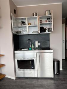 a kitchen with a sink and a microwave at Hafenblick in Schleswig