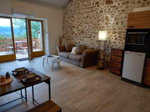 a living room with a couch and a table at Maison Neuve Parc Naturel livradois Forez Animal accepté in Tussigère