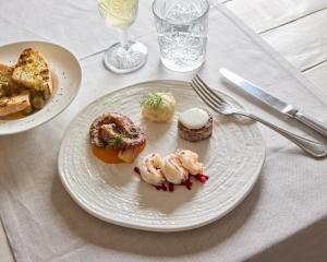 a plate of food with shrimp and bread on a table at La Casa E Il Mare, Private Bay Hotel in Mattinata