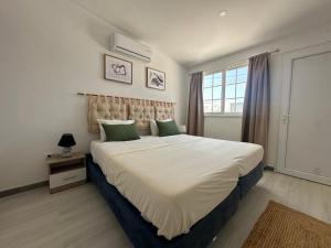 a bedroom with a large bed with green pillows at Casa da Calma - GUESTHOUSE in Alandroal