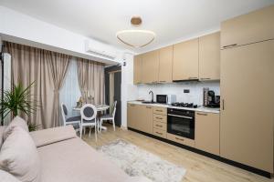 a kitchen and living room with a couch and a table at Regal Apartament Infinity Pool & Spa Mamaia North in Mamaia Nord
