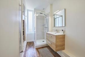 a bathroom with a shower and a sink and a mirror at Le Logis du Clergé - Grande maison pour 15p in Lassy +12 photos