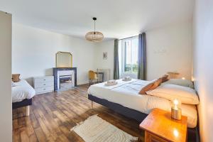 a bedroom with a large bed and a mirror at Le Logis du Clergé - Grande maison pour 15p in Lassy