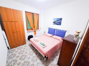 a small bedroom with a pink bed and a dresser at Casa dei Trabocchi 2-3 in San Vito Chietino