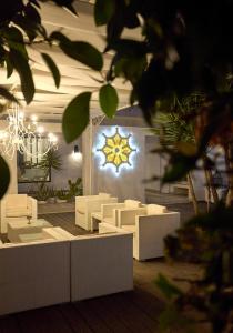 a room with white furniture and a chandelier at La Casa E Il Mare, Private Bay Hotel in Mattinata