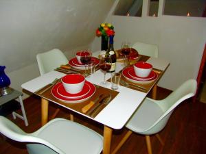 a table with red and white plates and wine glasses at Appartement la Belle Vue Panoramique in Sarlat-la-Canéda