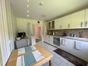a kitchen with white cabinets and a wooden table at Ferienwohnung Ahoi in Langwedel