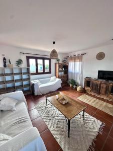 a living room with a couch and a table at Dreamwaves Surf House Fuerteventura in La Oliva