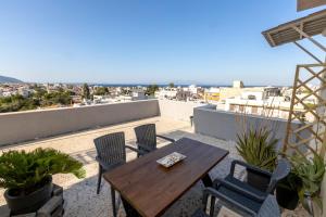 a patio with a wooden table and chairs on a roof at 360view in Chios