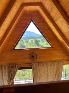 a window in a room with a wooden ceiling at Woodside Blidinje in Risovac +13 photos