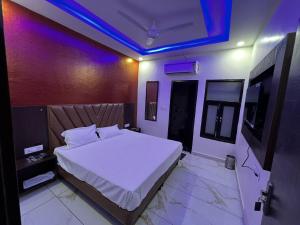 a bedroom with a white bed and a purple ceiling at Hotel AJL in Rohtak