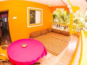 a living room with a couch and a pink table at Orange Villa in Morjim