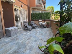 a patio with chairs and plants on a building at ZEFIRO OSTIA-Free parking & Terrace in Lido di Ostia