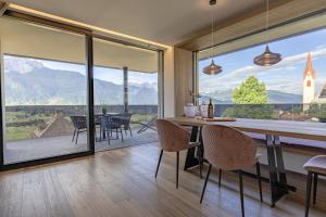 a dining room with a view of the mountains at Timeless Dolomites Apartments in Dobbiaco
