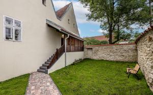 a house with a grass yard next to a building at Penzion Popelka in Roudnice nad Labem