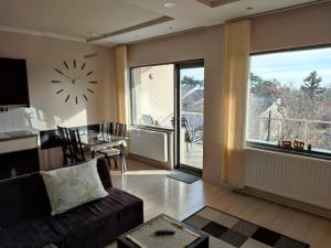 een woonkamer met een bank en een klok aan de muur bij LUX Apartman in Balatonfüred