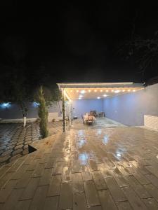 a patio at night with a table and lights at Cozy House with Swimming Pool near city center in Gabala