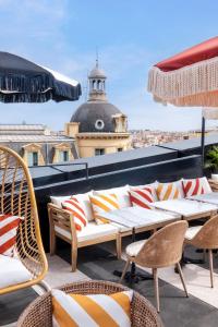 a patio with chairs and tables on a roof at Doubletree By Hilton Nice Centre Iconic in Nice