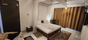 a small room with a bed and a window at Villa Salaam in Diani Beach +17 photos