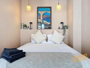 een slaapkamer met een groot bed met witte kussens bij Magnifique Studio - Hyper Central & Climatisation - Les Frères de la Loc' in Marseille