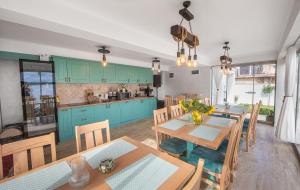 a kitchen with blue cabinets and wooden tables and chairs at Thaya Rooms in Mangalia