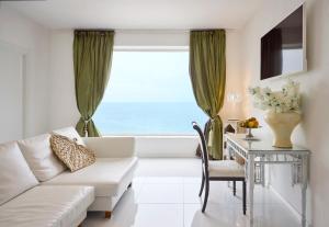 a living room with a couch and a table and a window at La Casa E Il Mare, Private Bay Hotel in Mattinata