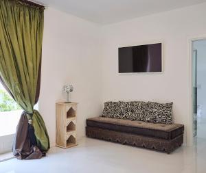 a living room with a couch and a television at La Casa E Il Mare, Private Bay Hotel in Mattinata