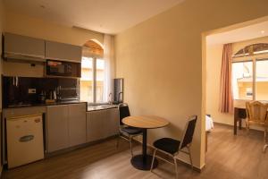 a kitchen with a table and chairs in a room at Aparthotel Madeleine in Antananarivo