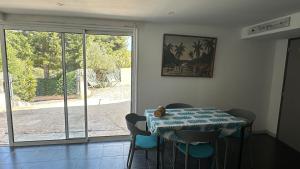 a dining room with a table and chairs and a window at Appartement Saint Cyr Sur Mer in Saint-Cyr-sur-Mer +5 photos