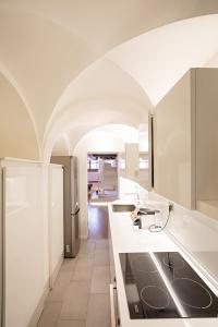 une cuisine avec des comptoirs blancs et un plafond voûté dans l'établissement Pantheon Luxury Apartment, à Rome