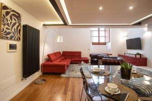 a living room with a red couch and a table at Pantheon Luxury Apartment in Rome