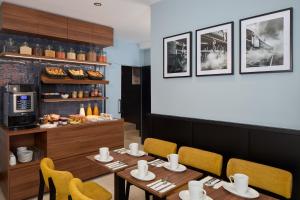 a dining room with a table and chairs and a counter at Timhotel Paris du Gare du Nord in Paris