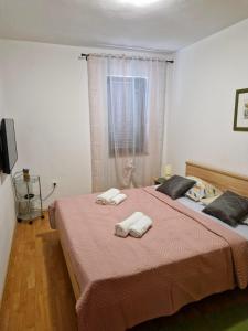 a bedroom with a large bed with two towels on it at Apartman Seka in Kraljevica