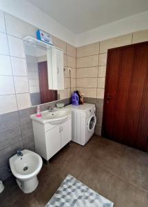 a bathroom with a toilet sink and a washing machine at Apartman Seka in Kraljevica +11 photos