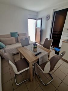a living room with a wooden table and chairs at Apartman Seka in Kraljevica