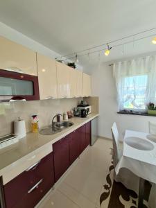 a white kitchen with a sink and a table at WILLA RÓŻA WIATRÓW in Dziwnówek